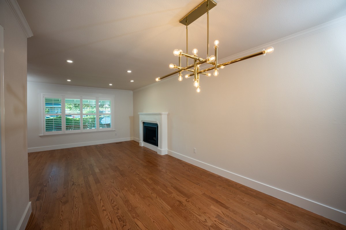 M+D remodel — living room with brass chandelier and fireplace